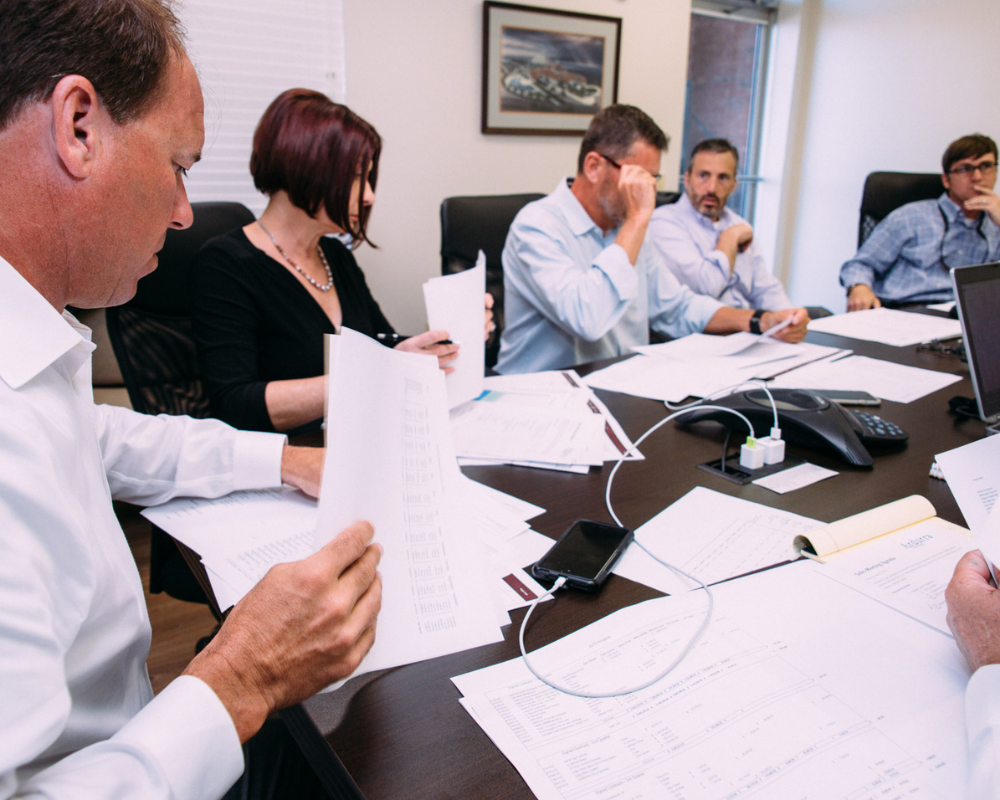 People reviewing papers at a conference table in a meeting room