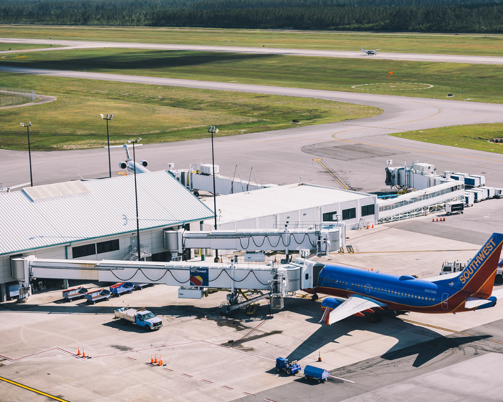 Airplane at gate connected to jet bridges at airport terminal