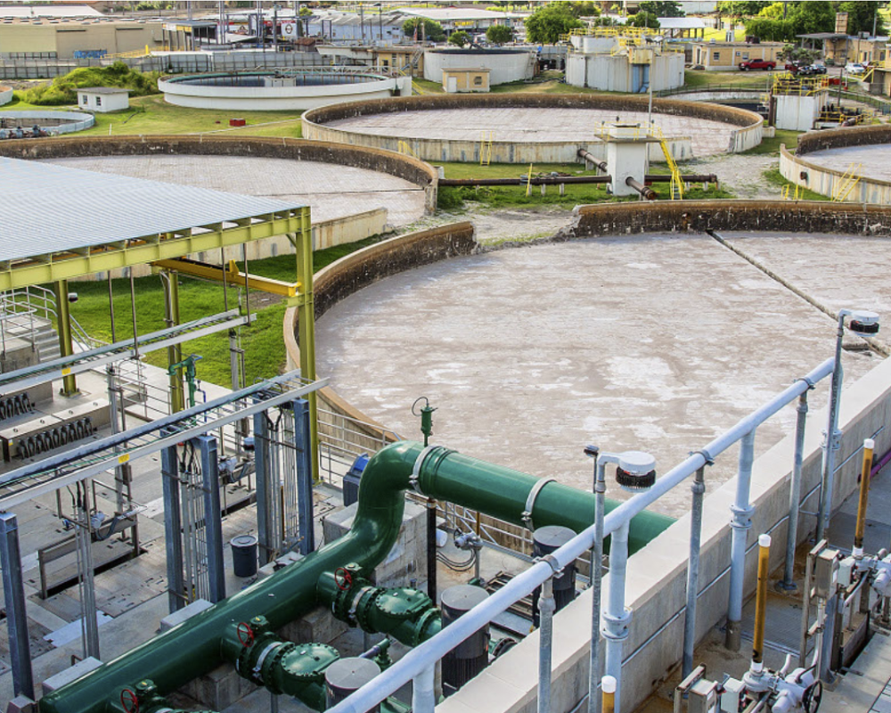 Industrial wastewater treatment plant with large circular tanks and piping
