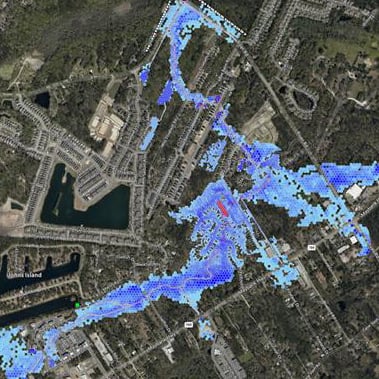 Aerial map with blue flood extent overlay and highlighted stream near roads and residential area